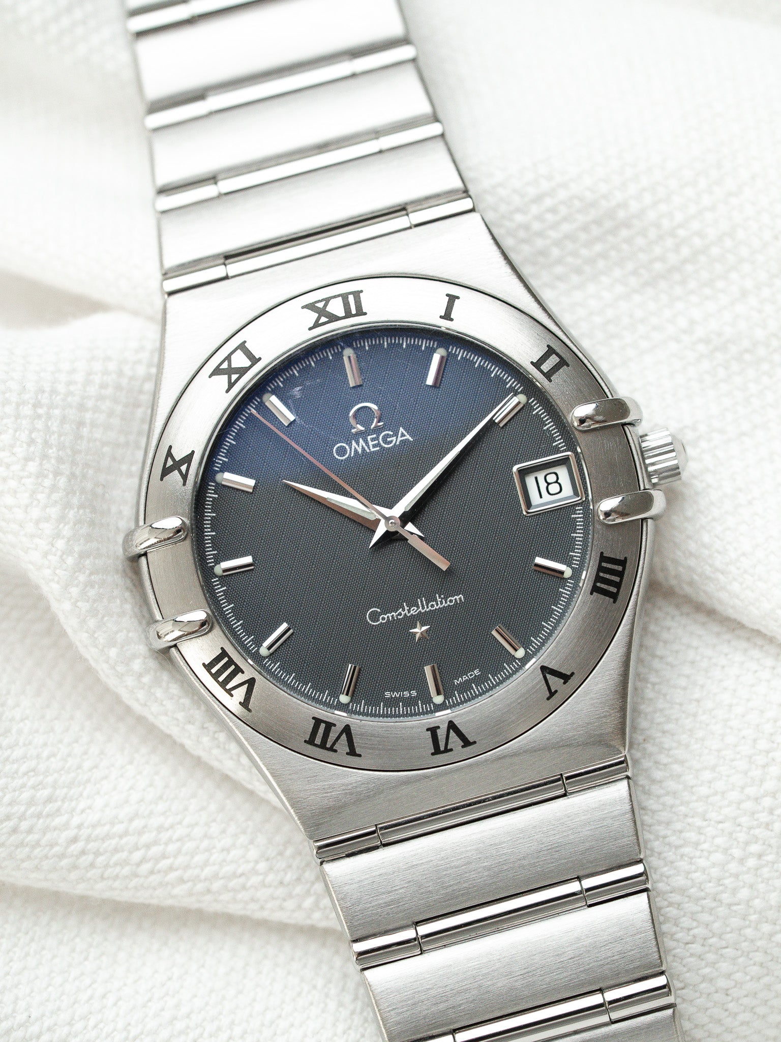 Omega Constellation watch with blue dial, steel bracelet, Roman numerals, date window at 3 o'clock