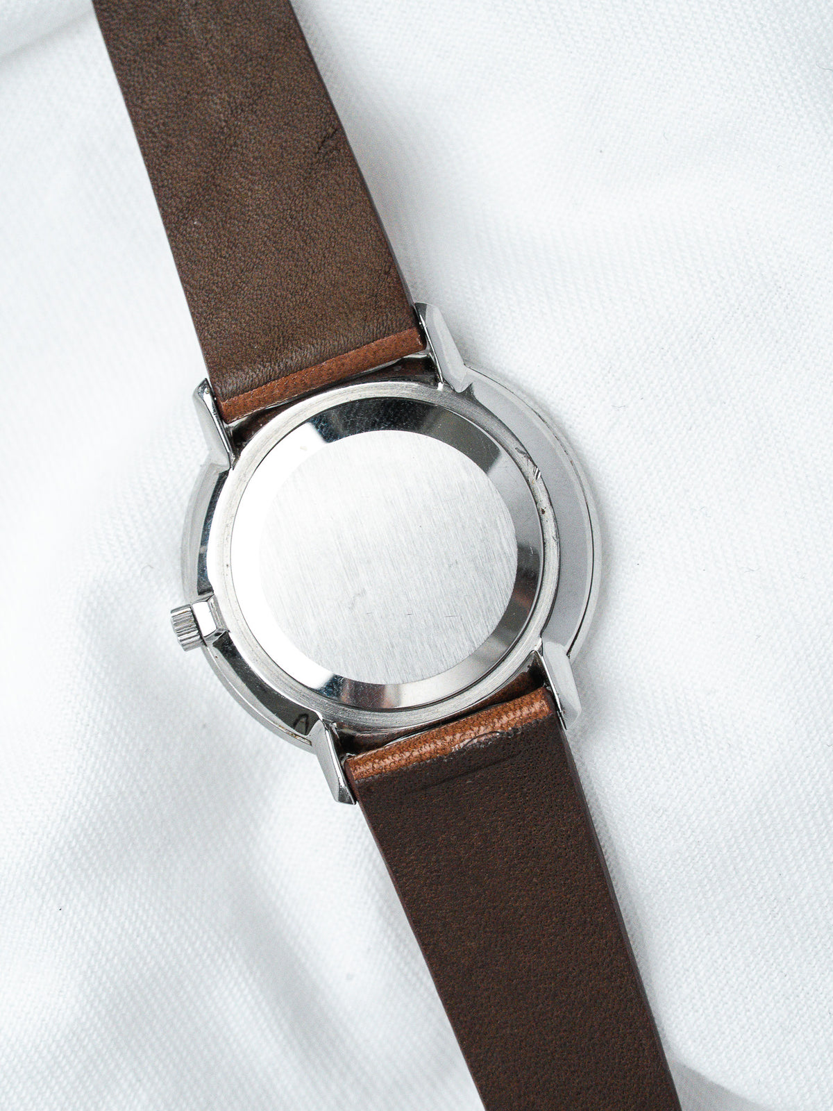 Vintage watch with brown leather strap and stainless steel case back