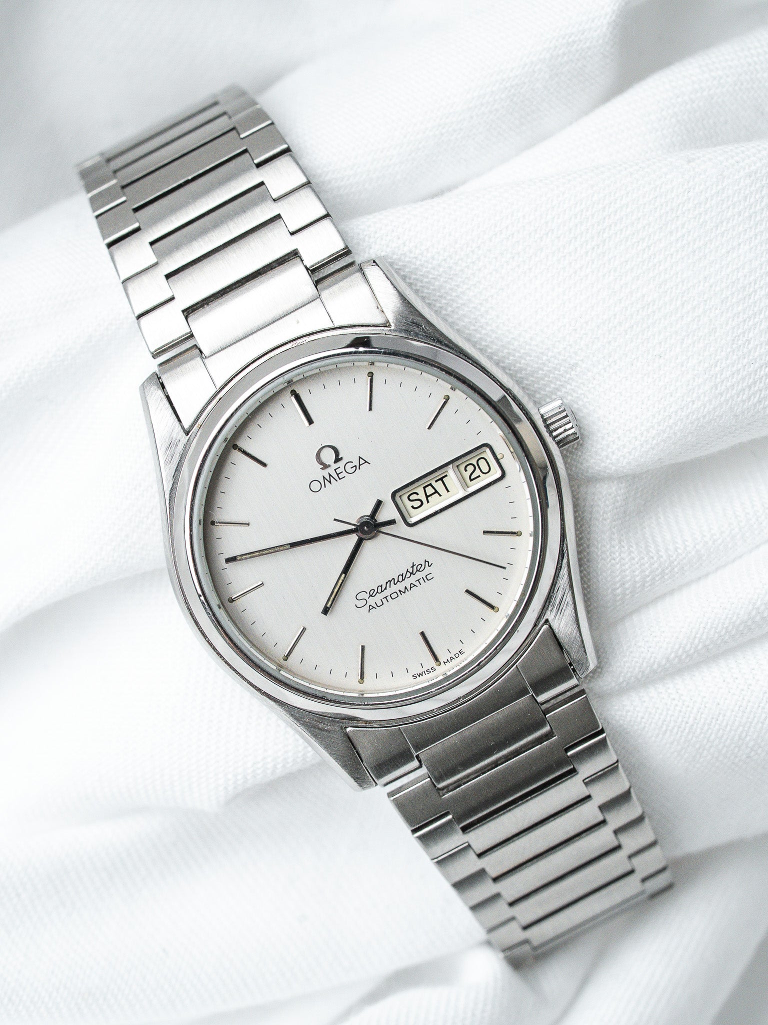 Omega Seamaster vintage automatic watch with silver dial and steel bracelet on white fabric