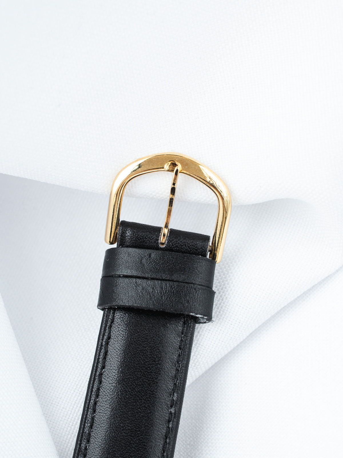 Black leather watch strap with gold buckle on white background