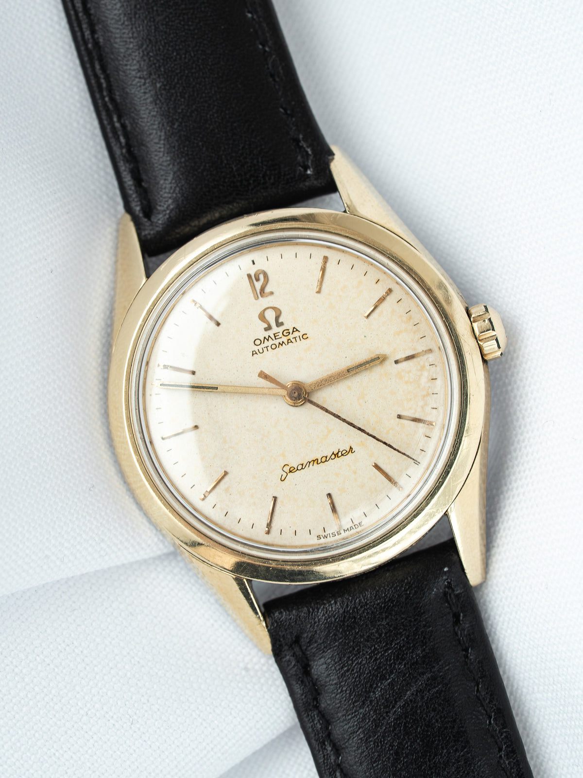 Omega Seamaster vintage watch with gold case, cream dial, and black leather strap