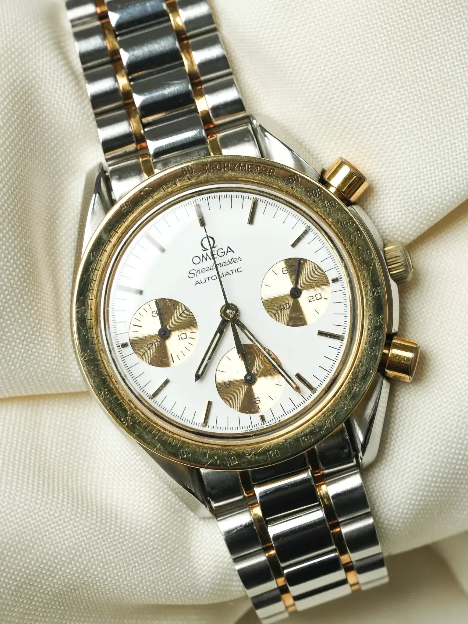 Omega Speedmaster Automatic vintage watch with white dial, gold subdials, and two-tone bracelet