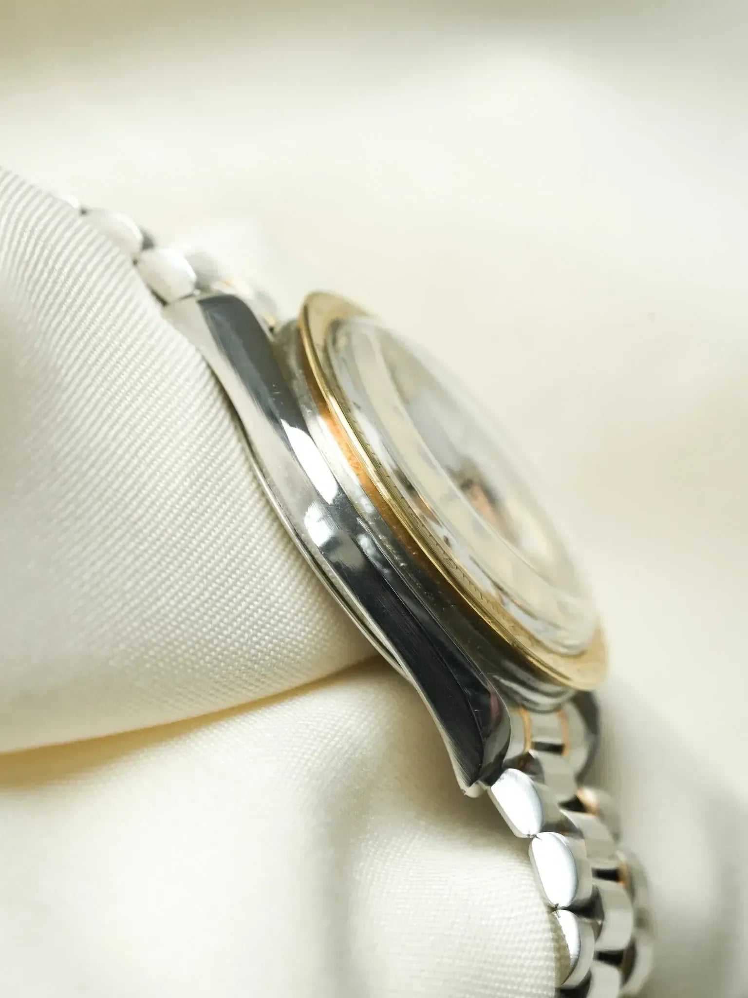Rolex vintage watch with two-tone steel and gold case, bracelet on white fabric