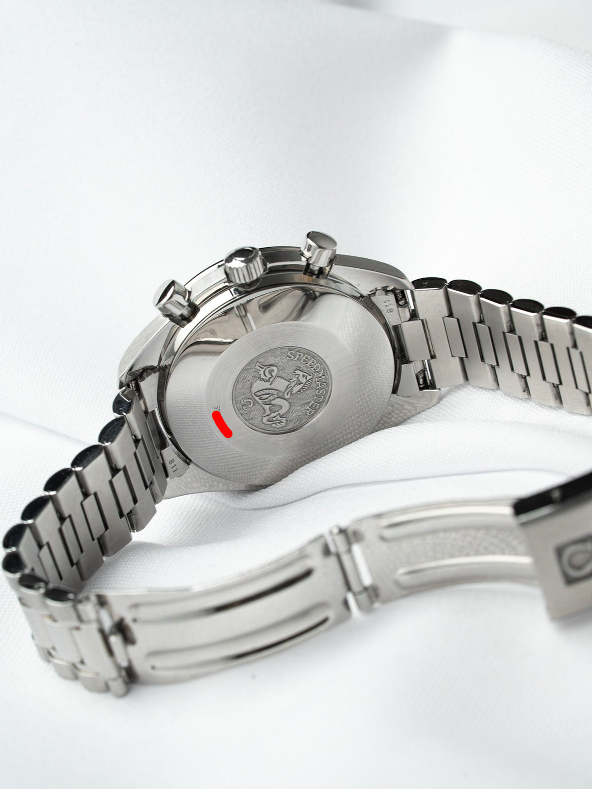 Omega Speedmaster vintage stainless steel watch back with engraved logo and red accent