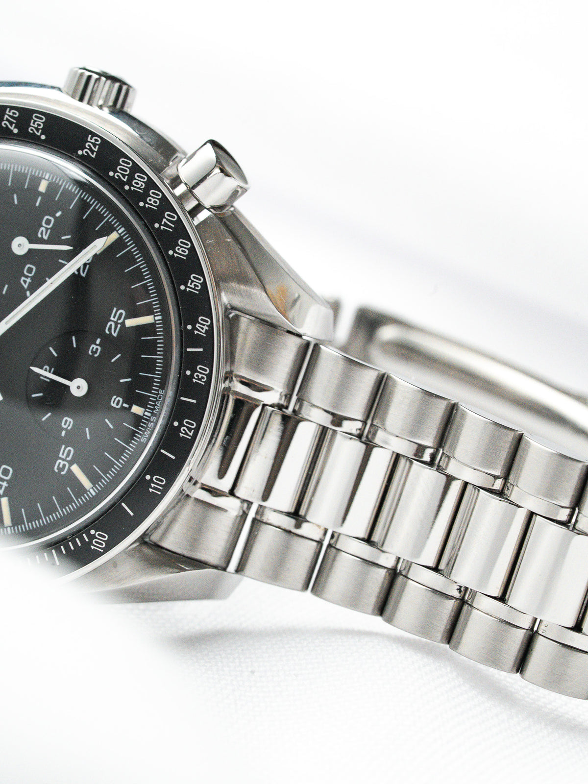 Omega Speedmaster vintage chronograph with black dial, steel case and bracelet on white background
