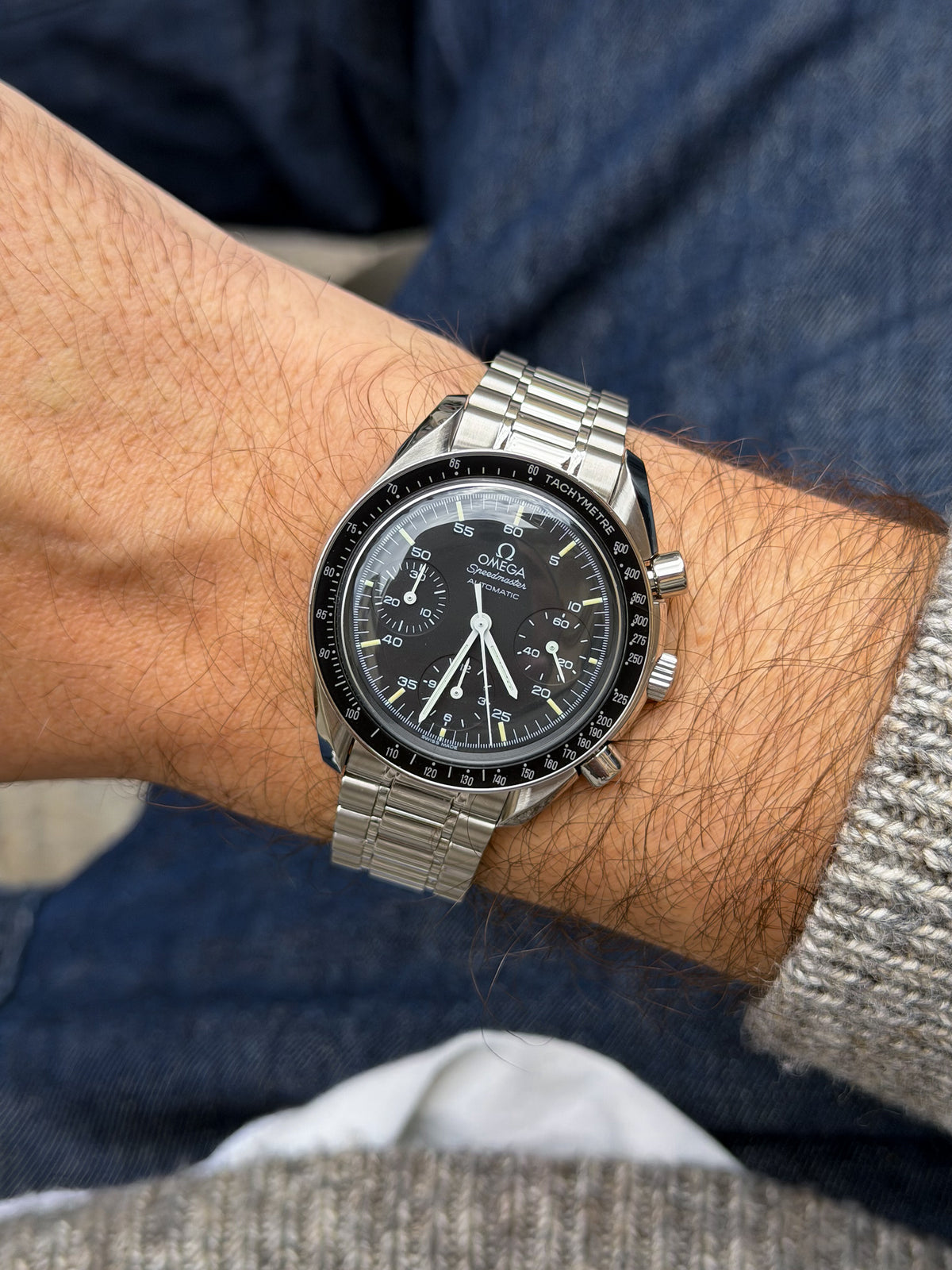 Omega Speedmaster Automatic vintage watch with black dial, steel bracelet, worn on wrist