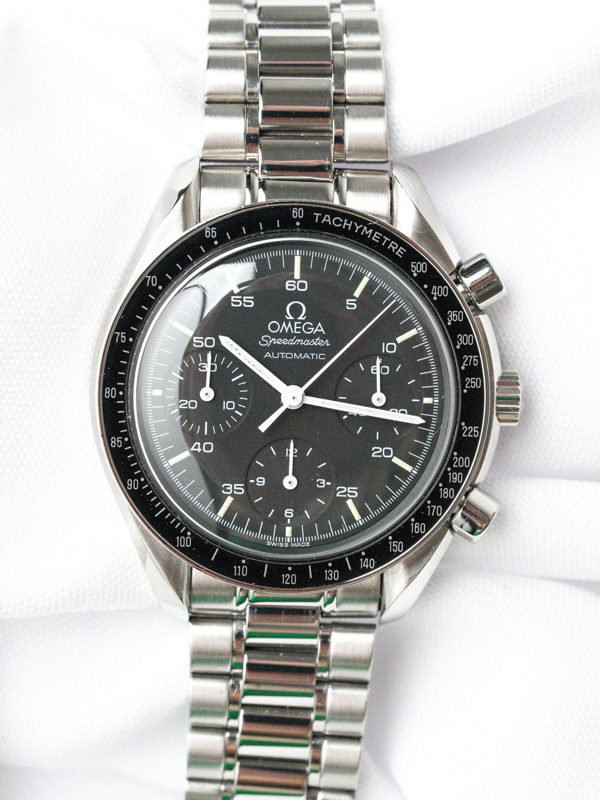 Omega Speedmaster Automatic vintage watch with black dial, steel bracelet, tachymeter bezel on white background