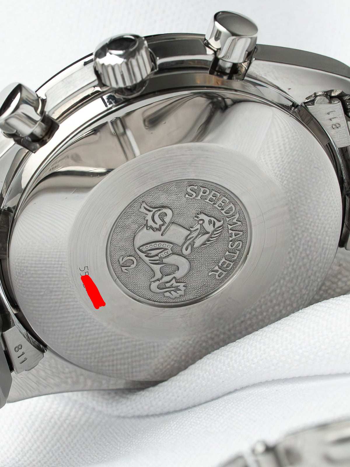 Omega Speedmaster case back with engraved dragon motif and textured steel finish