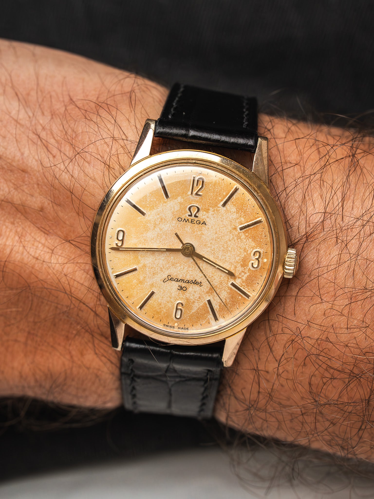 Vintage Omega Seamaster 30 watch with gold case, aged dial, black leather strap on wrist