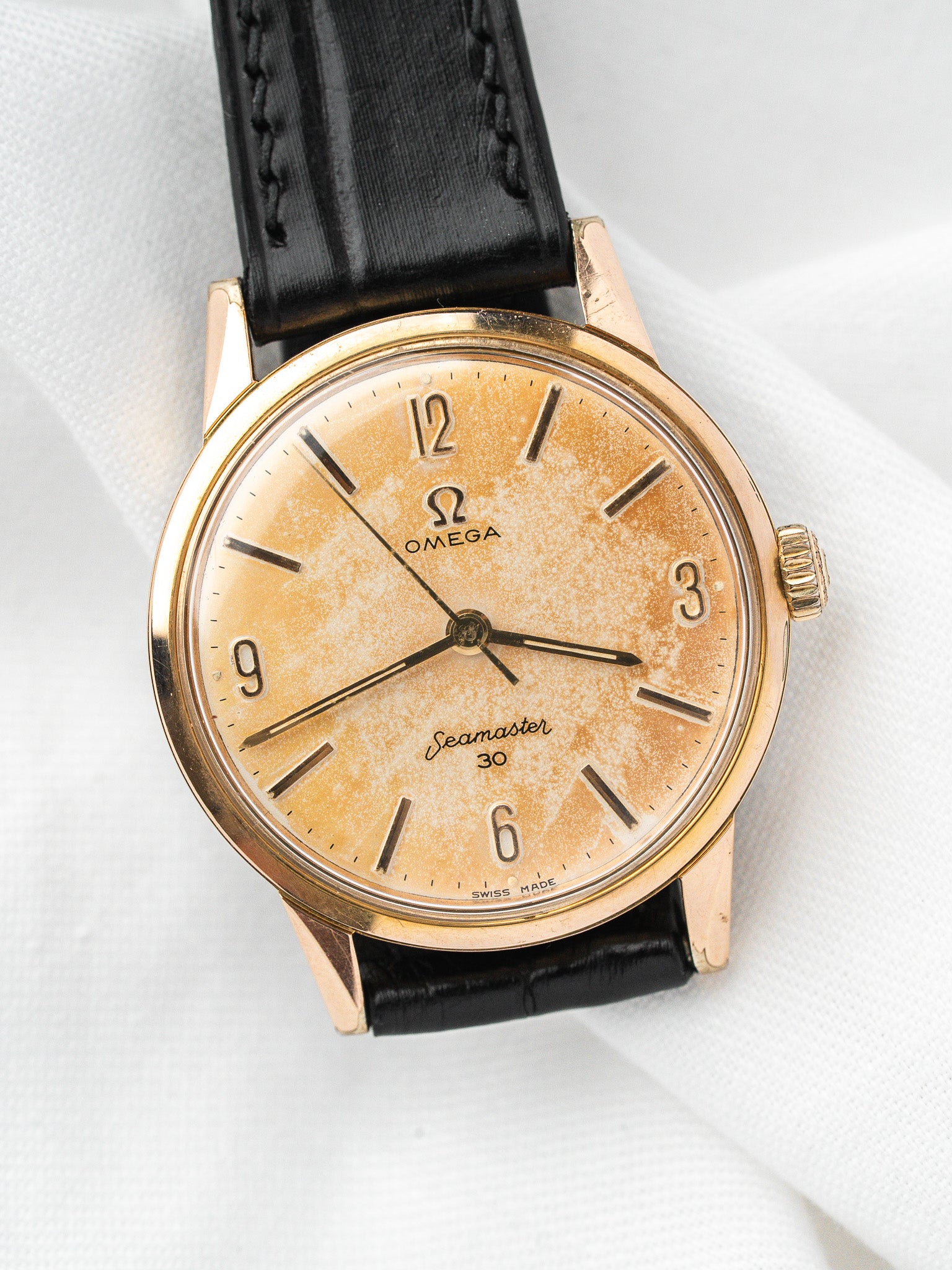 Vintage Omega Seamaster 30 watch with gold case, cream dial, and black leather strap