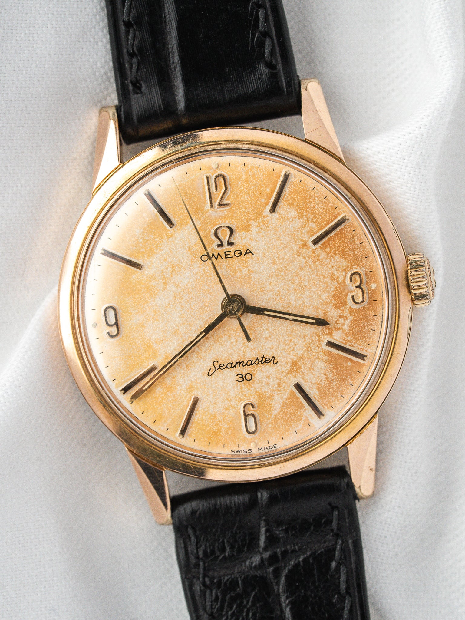 Vintage Omega Seamaster 30 watch with gold case, cream dial, and black leather strap
