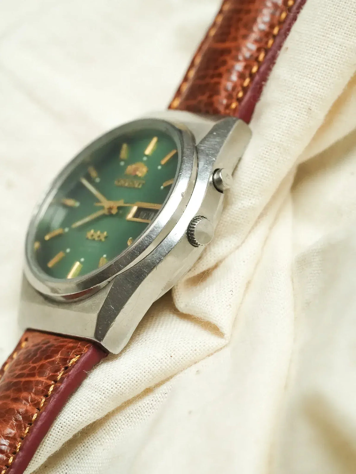 Vintage Seiko watch with green dial, gold markers, stainless steel case, brown leather strap