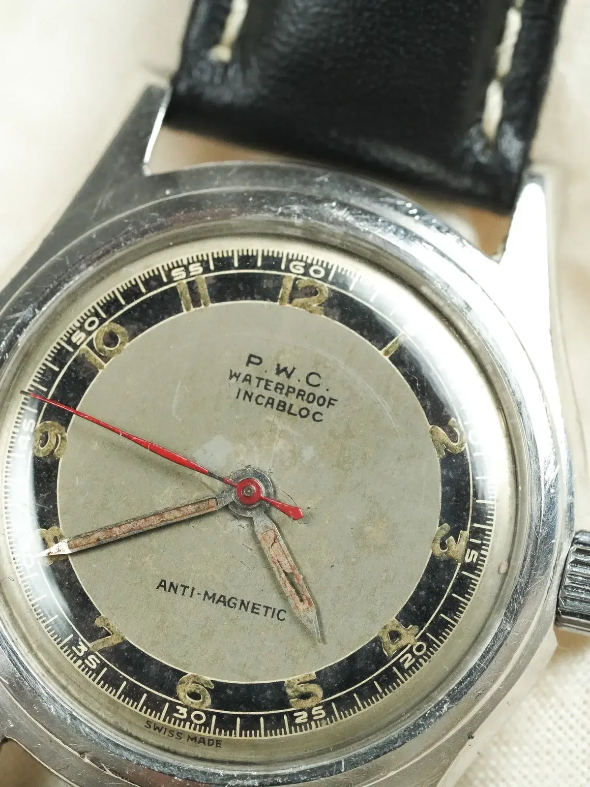P.W.C. vintage watch with grey dial, red seconds hand, black leather strap