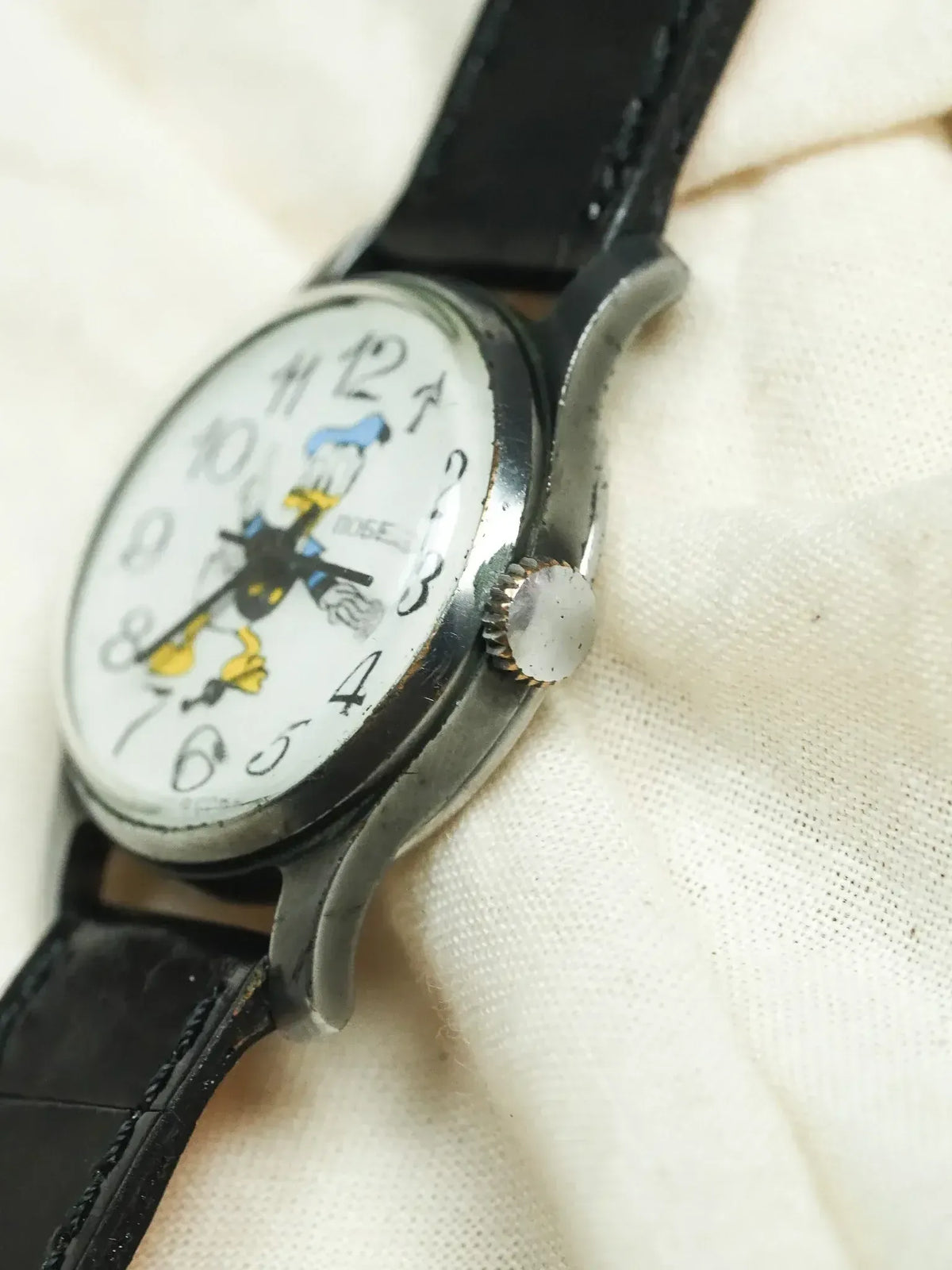 Vintage Ingersoll Donald Duck watch with white dial, black leather strap, silver case