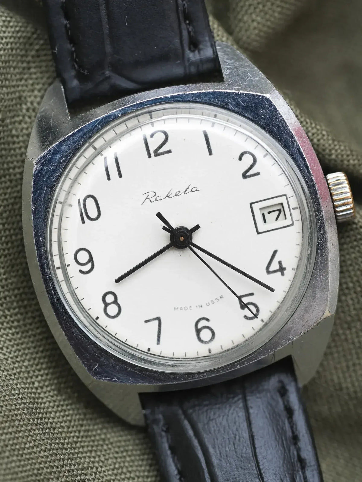 Raketa vintage watch with white dial, black leather strap, and date window