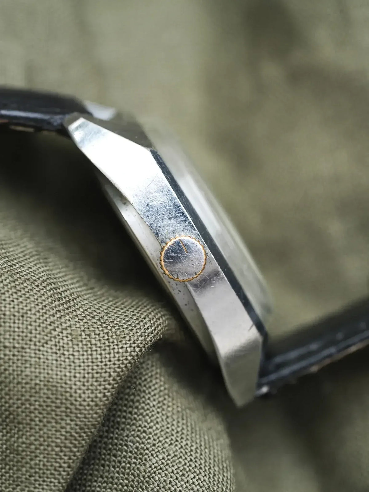Vintage Cartier watch side view, steel case, gold crown, black leather strap