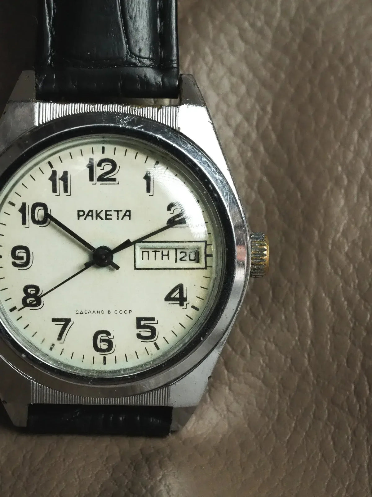 Vintage Raketa watch with white dial, black leather strap, USSR-made, day-date display