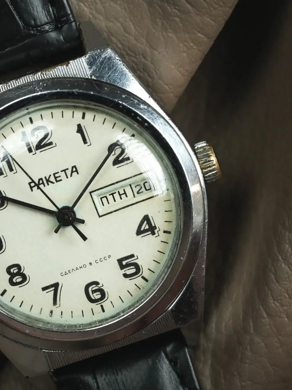 Raketa vintage watch with white dial, black numerals, and black leather strap