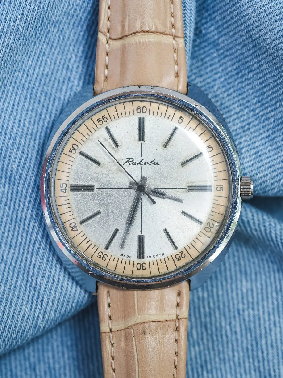 Raketa vintage watch with silver dial, beige leather strap, worn on denim