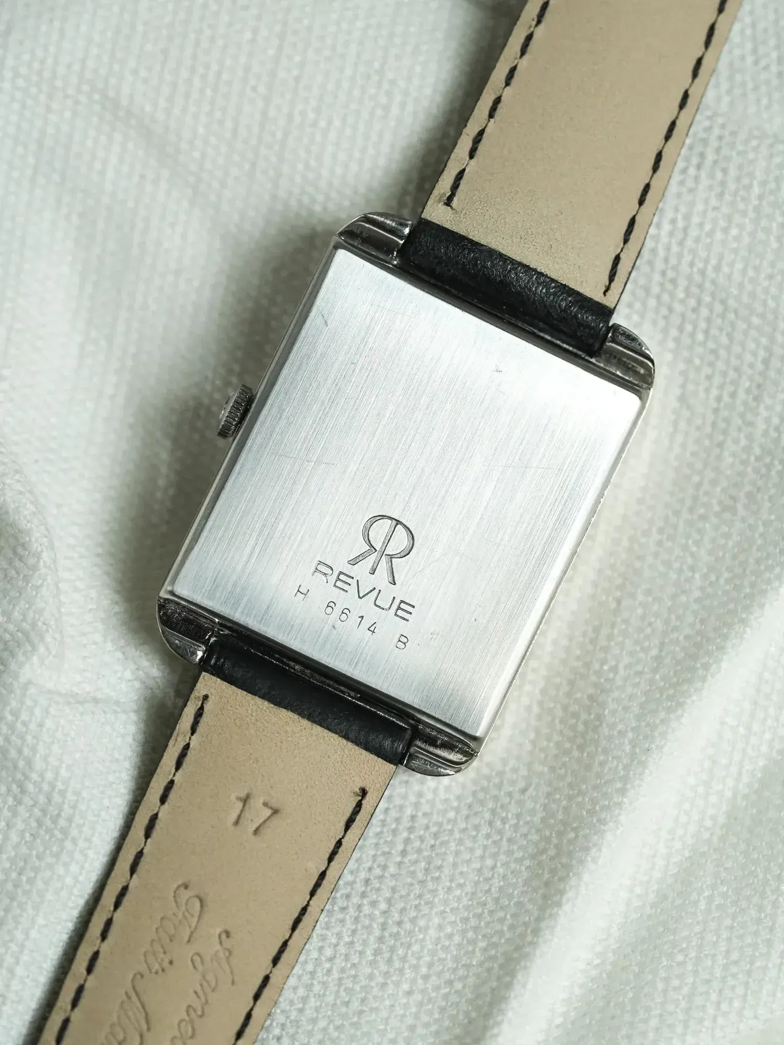 Revue vintage watch with rectangular case, brushed steel back, and beige leather strap