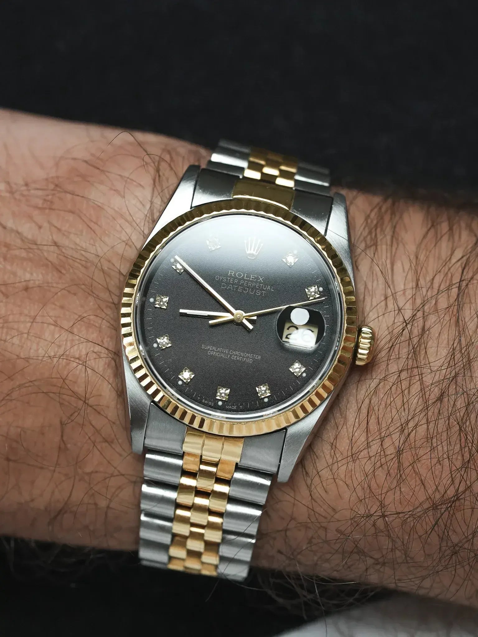 Rolex Datejust vintage with black diamond dial, two-tone steel and gold bracelet worn on wrist