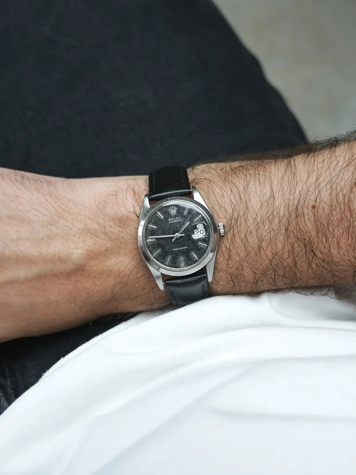 Rolex Oysterdate vintage watch with black dial and leather strap on wrist