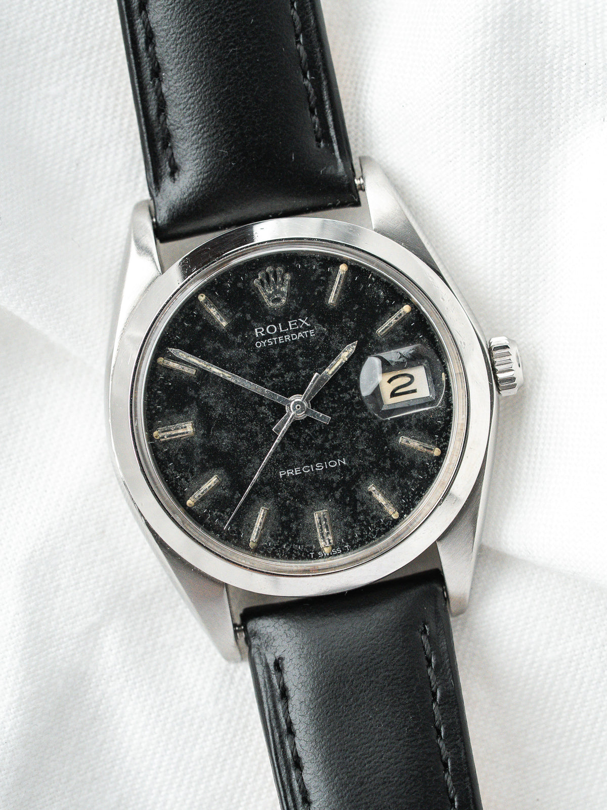 Montre Rolex Oysterdate vintage, cadran noir patiné, boîtier acier et bracelet cuir noir