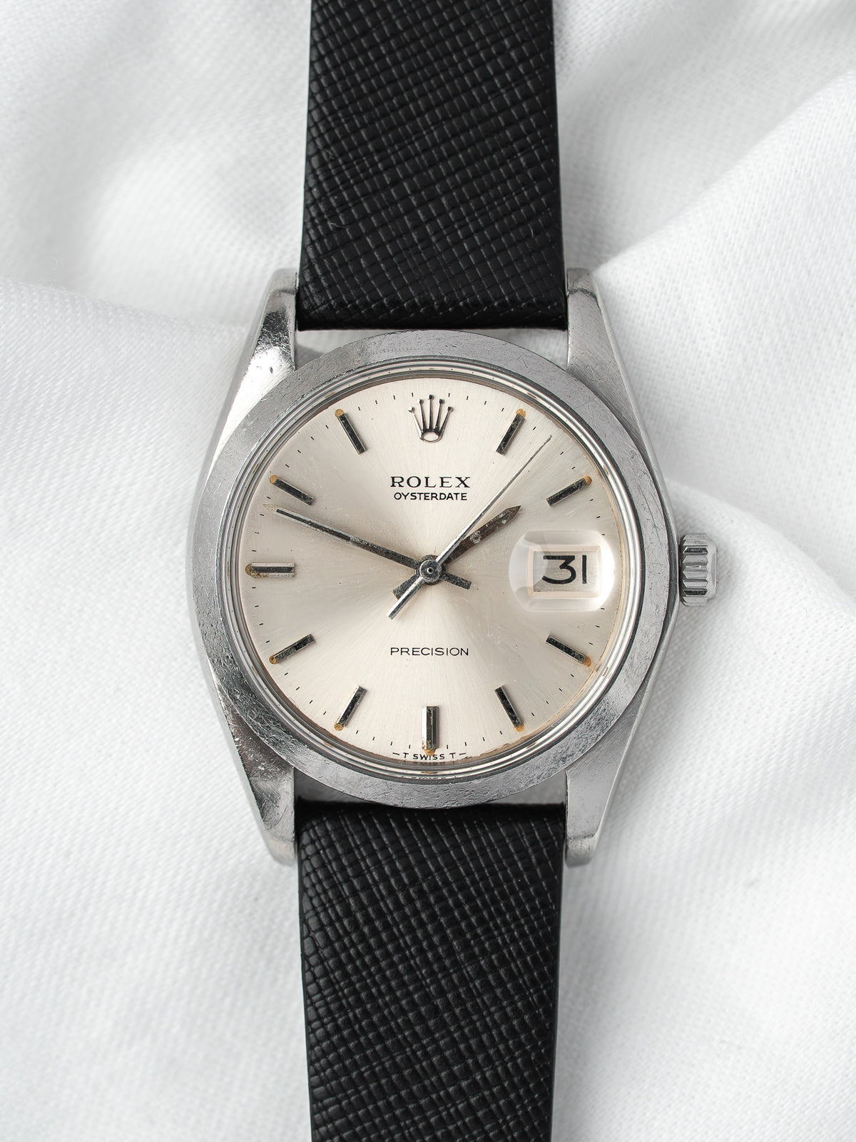 Rolex Oysterdate vintage watch with silver dial, black strap, and date display