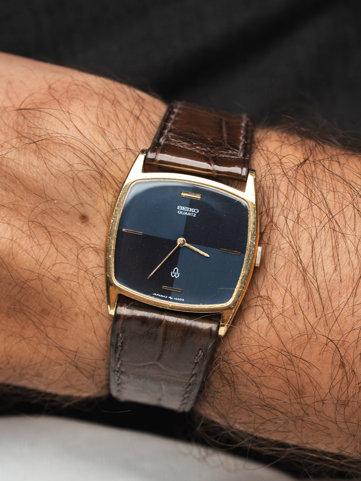Montre Seiko Quartz vintage avec cadran bleu foncé et bracelet en cuir marron.