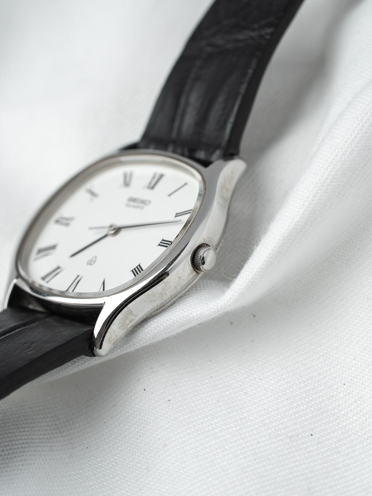 Seiko vintage watch with white dial, Roman numerals, black leather strap