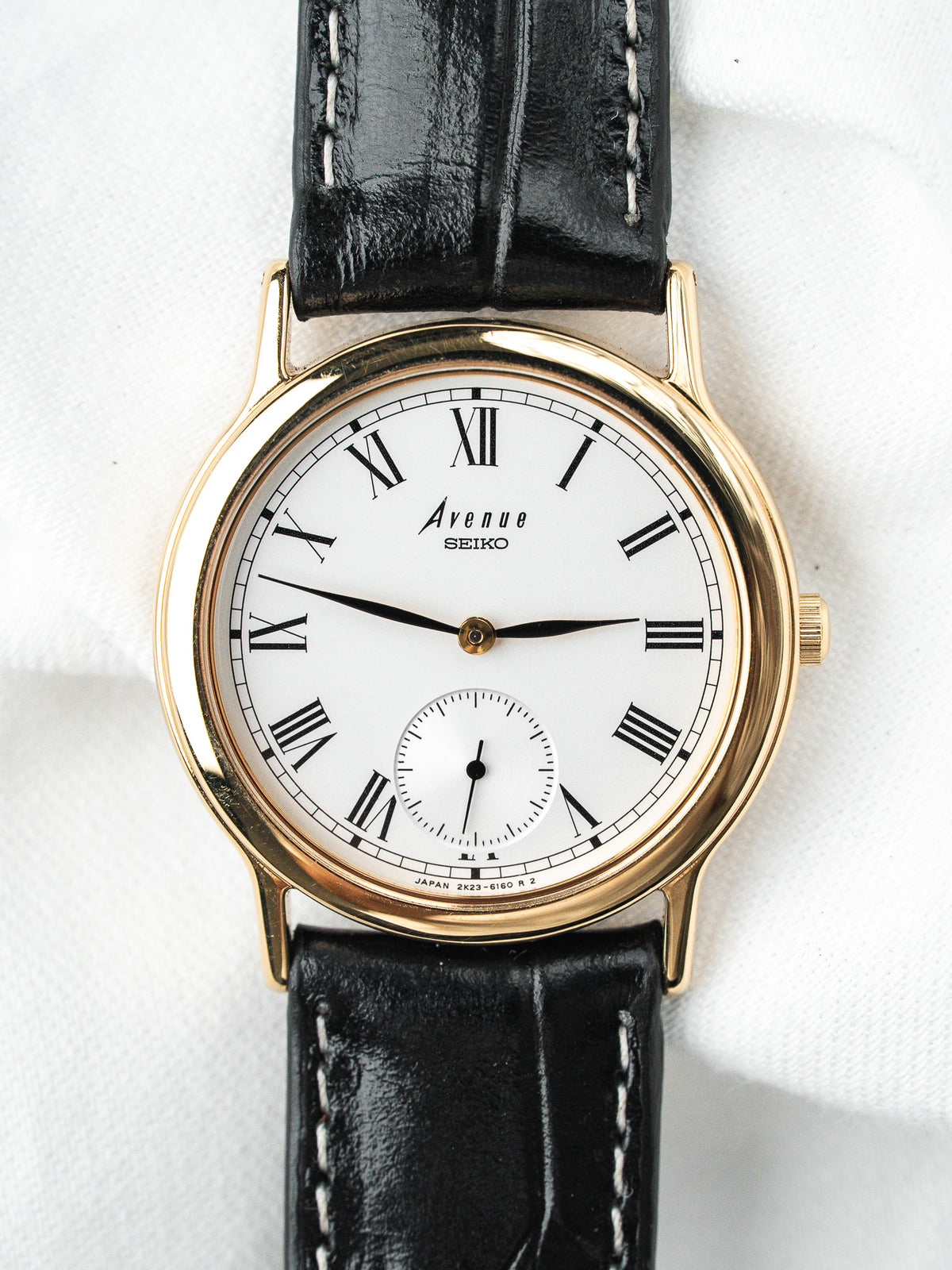 Montre Seiko Avenue vintage, boîtier doré, cadran blanc et bracelet en cuir noir