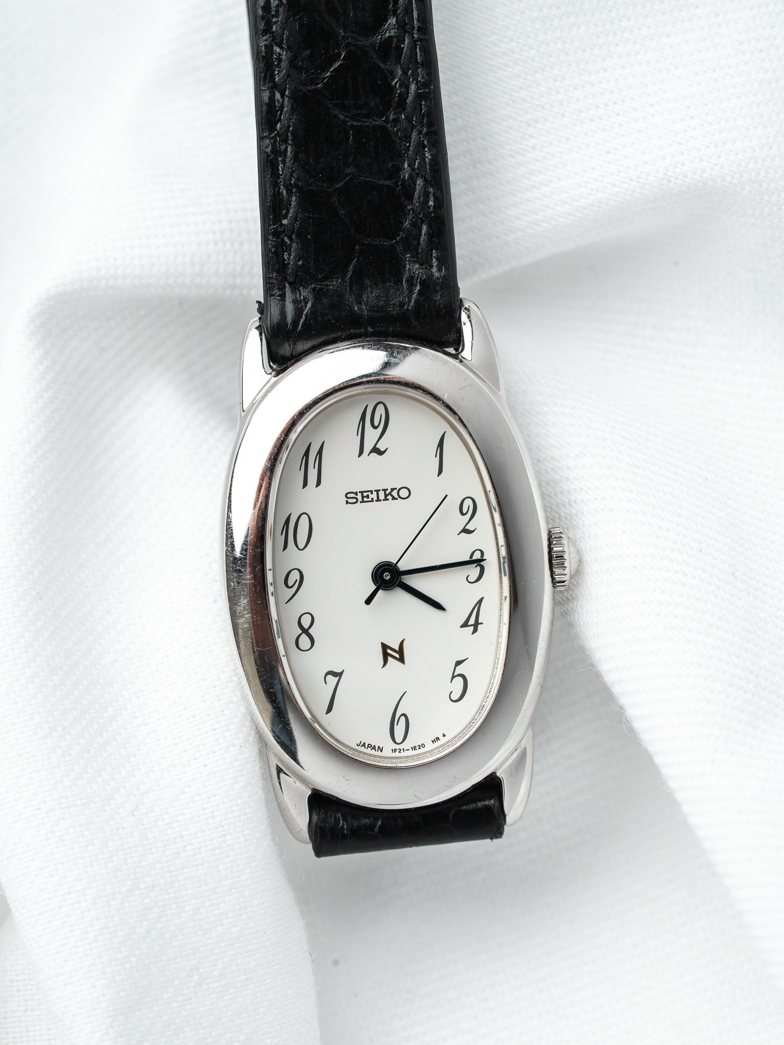 Seiko vintage watch with white dial, black leather strap, and silver case