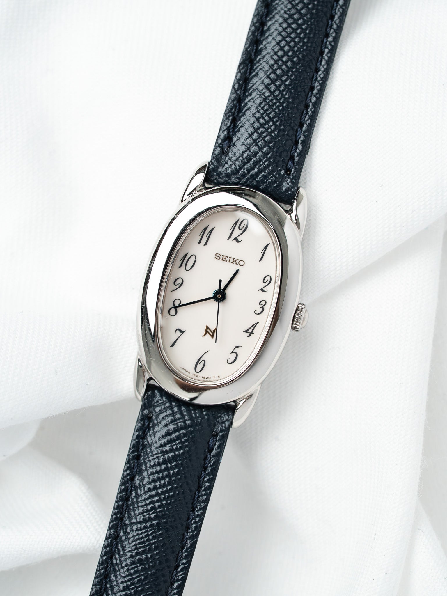 Seiko vintage watch with white dial, black leather strap, and silver case