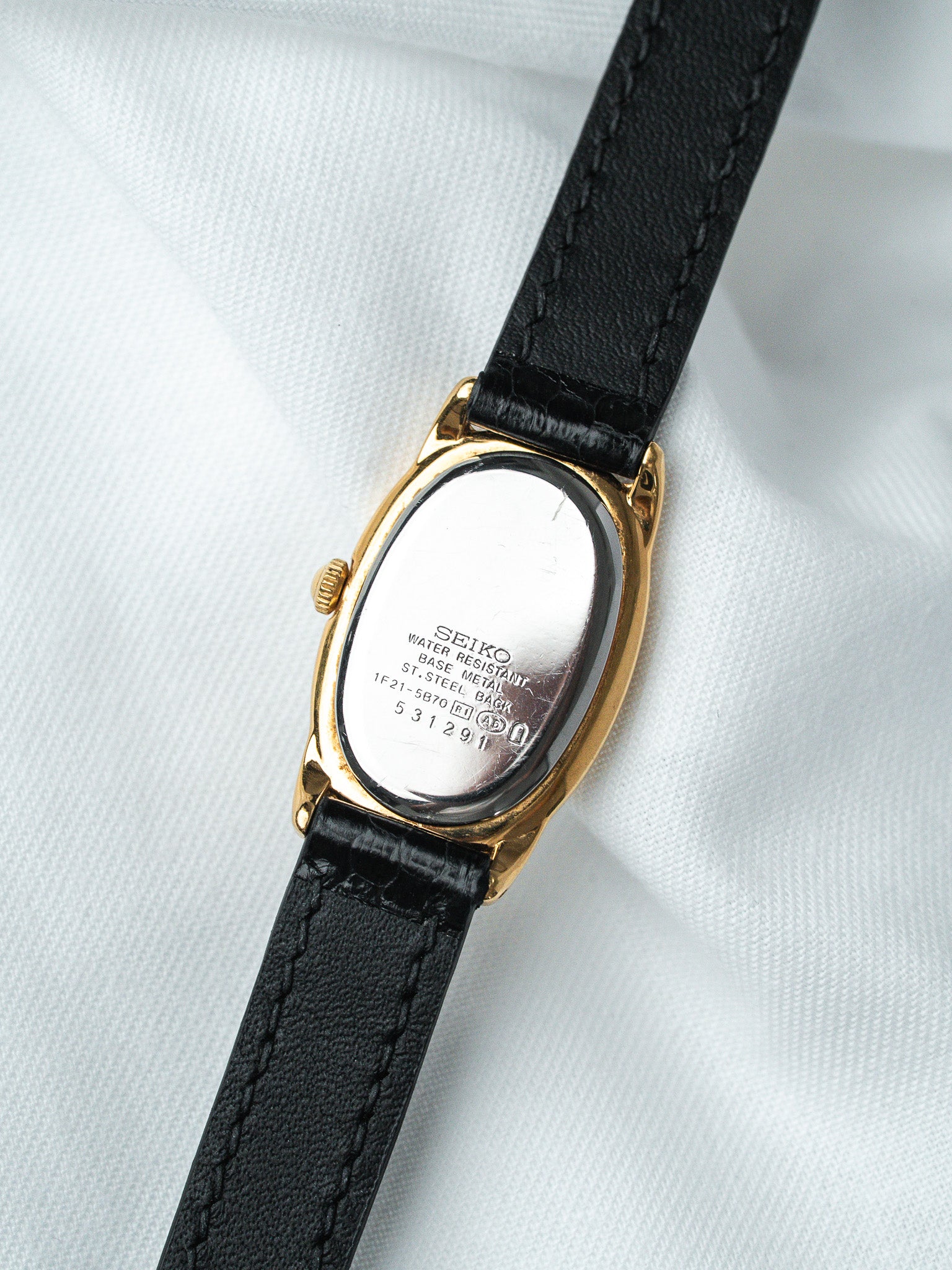 Seiko vintage watch with gold case, black leather strap, stainless steel back