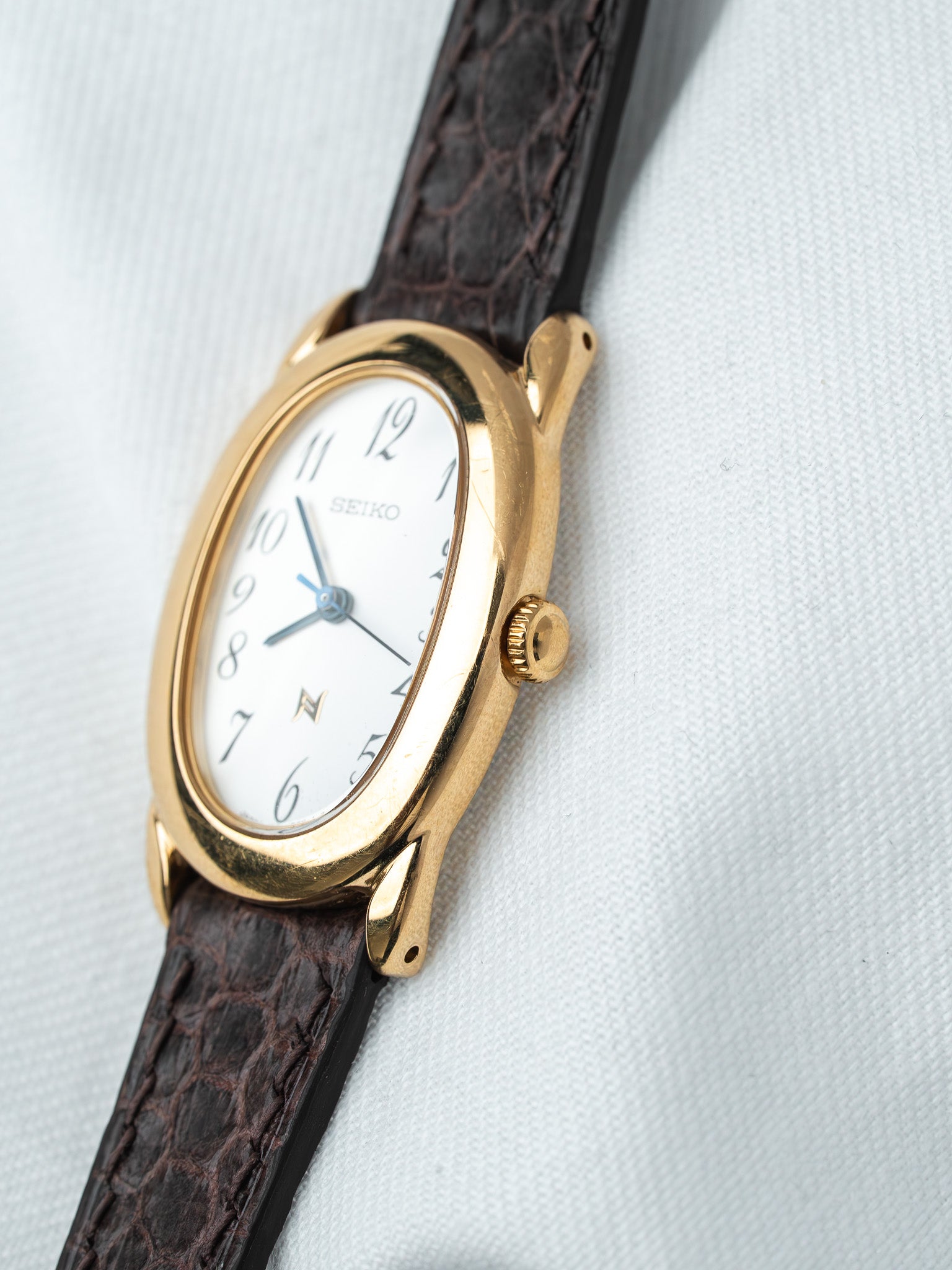 Seiko vintage watch with gold case, white dial, and brown alligator strap