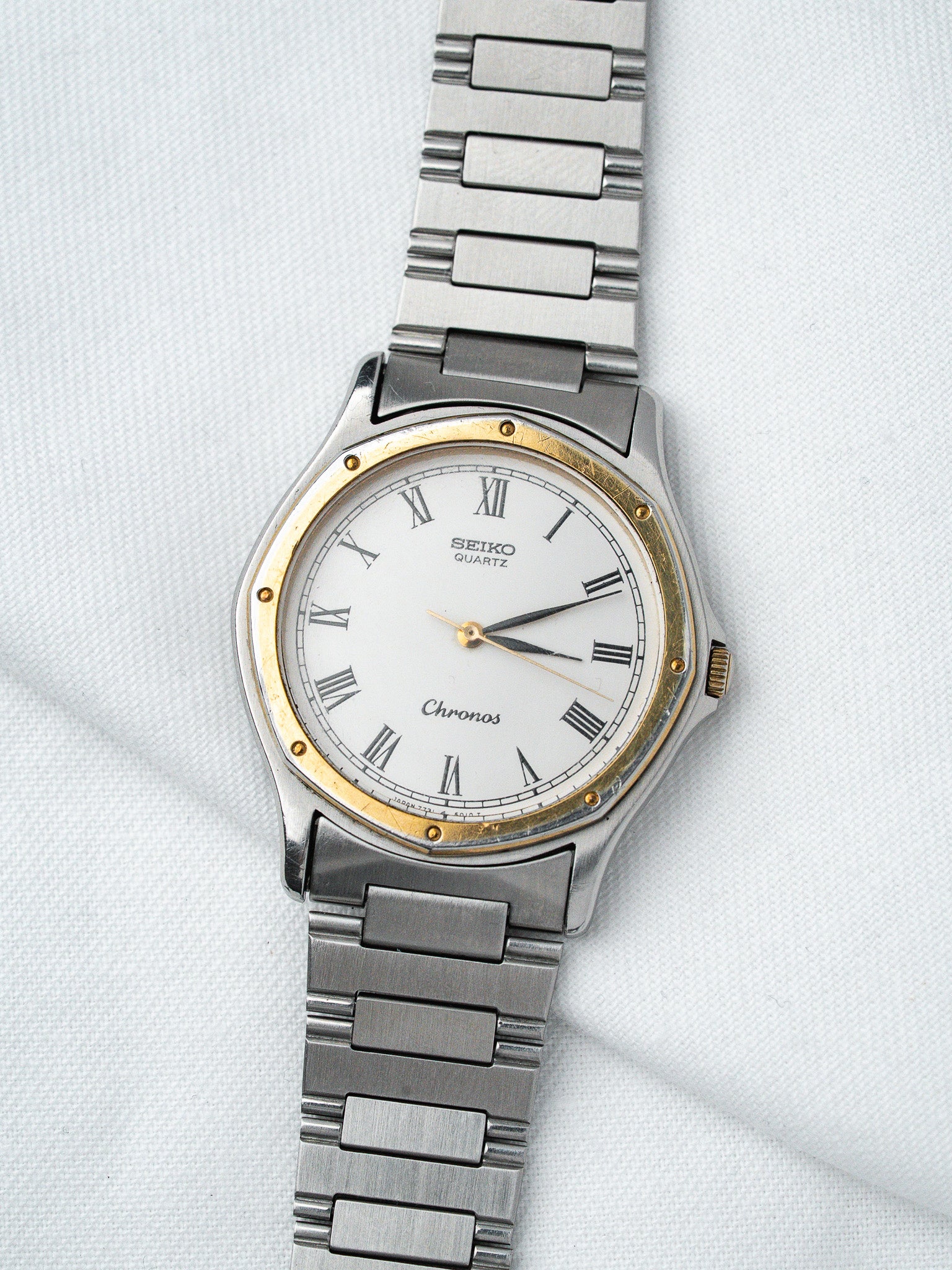 Seiko Chronos vintage quartz watch with white dial, Roman numerals, and two-tone steel bracelet