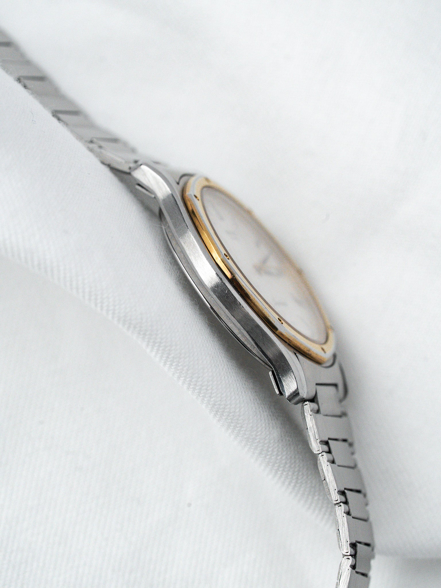 Vintage Omega Constellation watch with two-tone steel and gold case, white dial, bracelet on white fabric