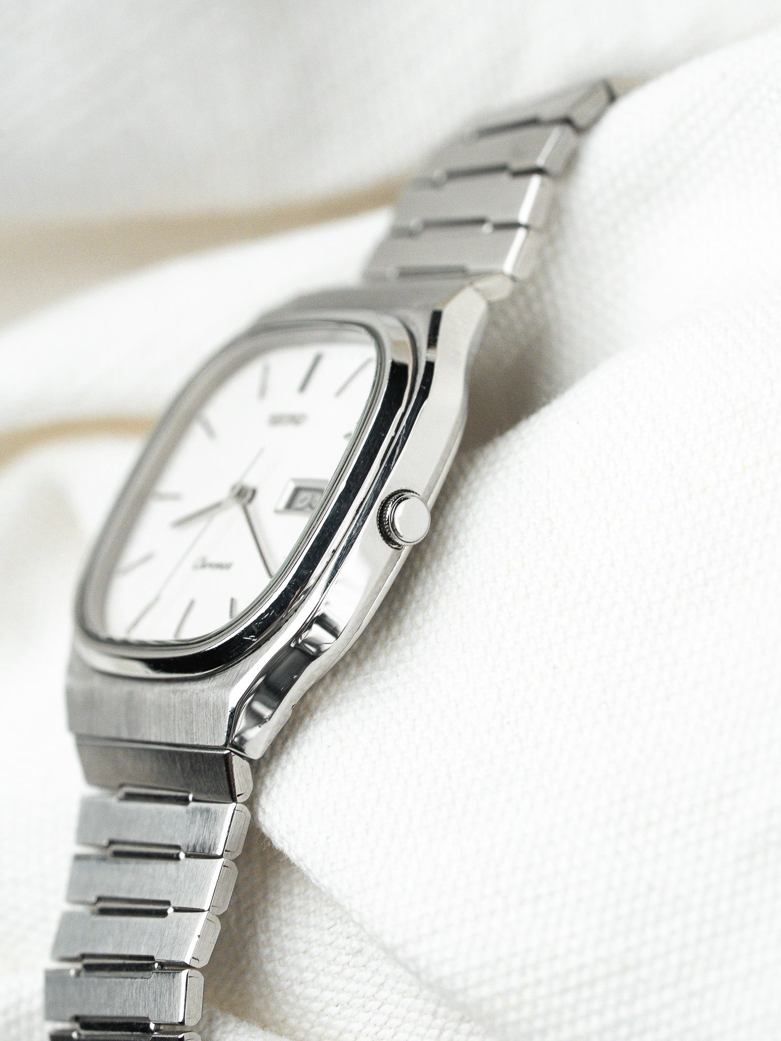 Seiko vintage watch with white dial, steel case and bracelet, displayed on white fabric