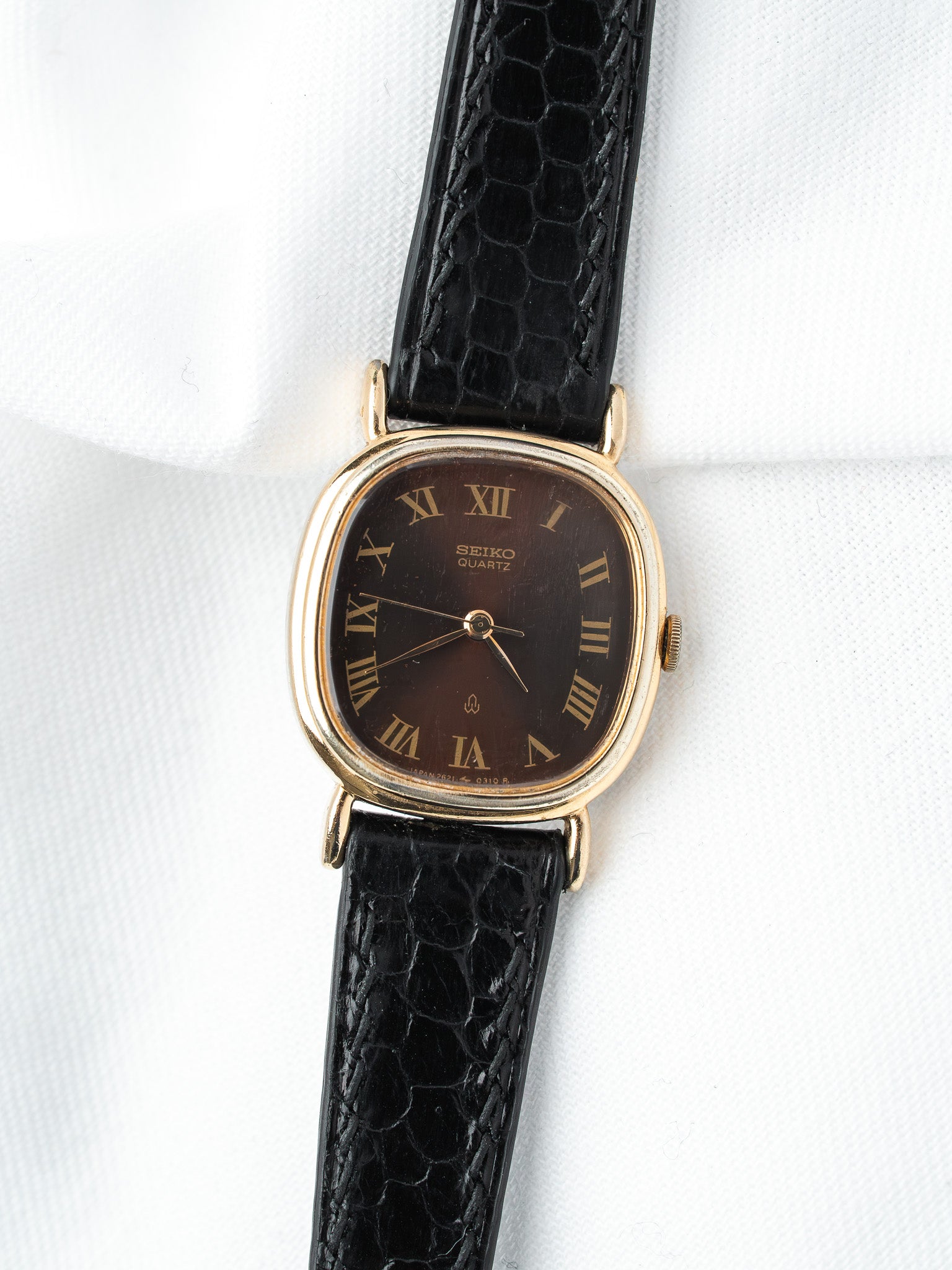 Seiko Quartz vintage watch with gold case, brown dial, Roman numerals, black crocodile strap