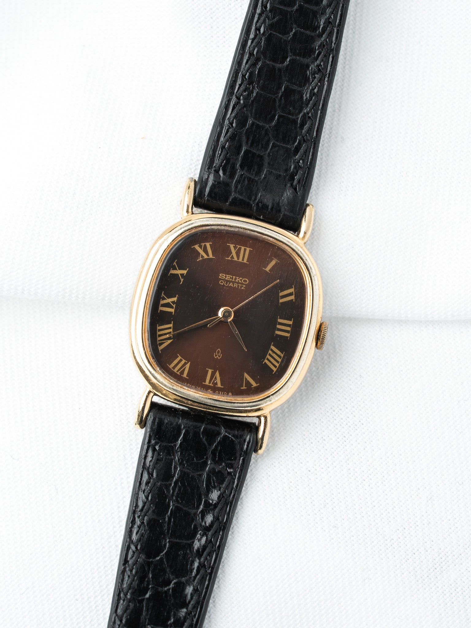 Seiko Quartz vintage watch with gold case, brown dial, Roman numerals, black crocodile strap