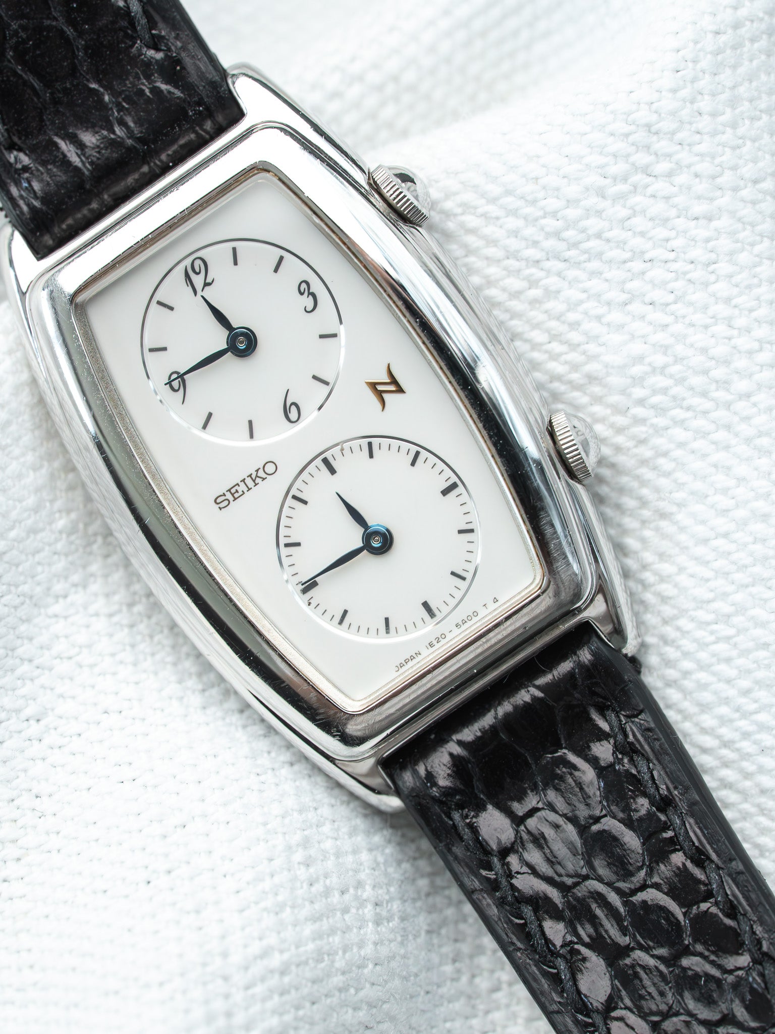 Seiko vintage watch with white dial, black leather strap, and silver case