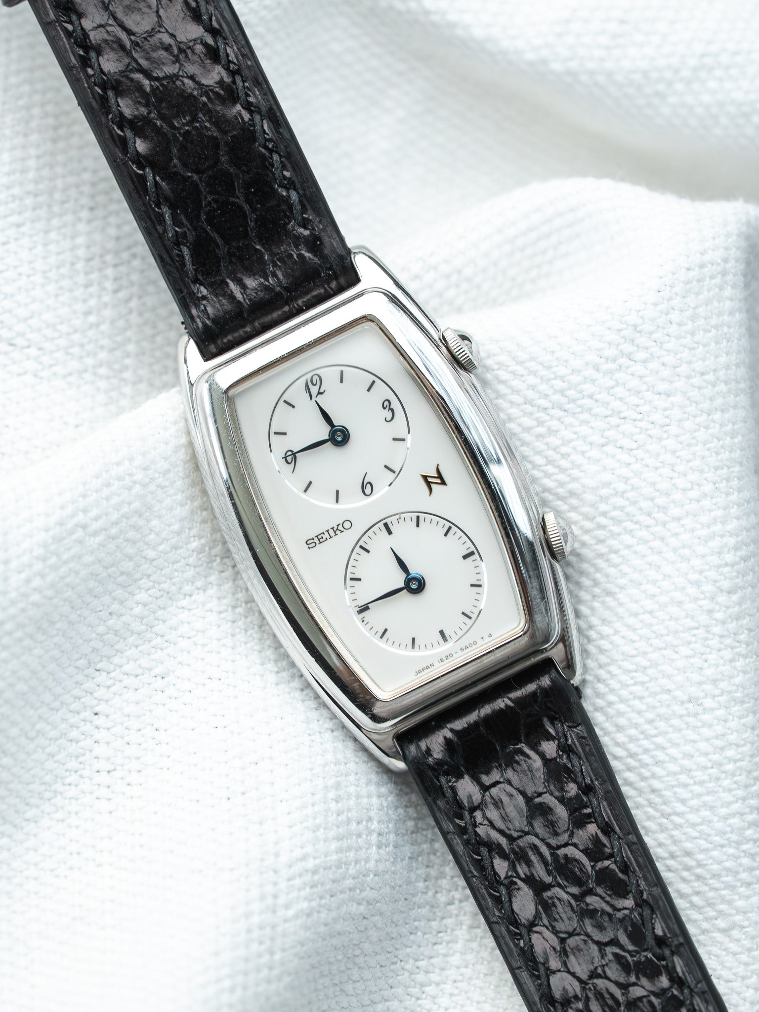 Seiko vintage watch with white dial, black leather strap, and silver case