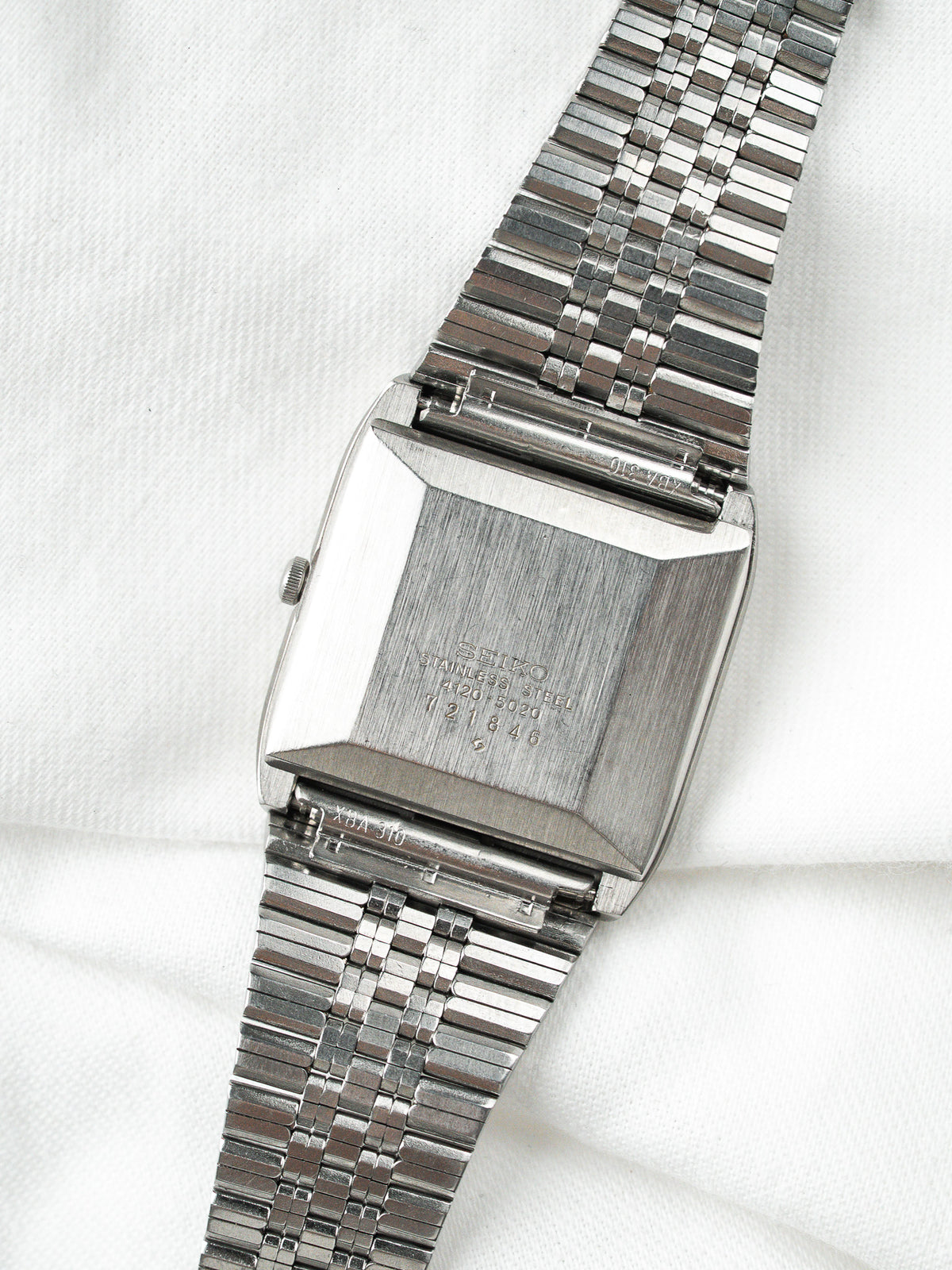 Dos d'une montre Seiko vintage en acier avec bracelet à mailles fines.