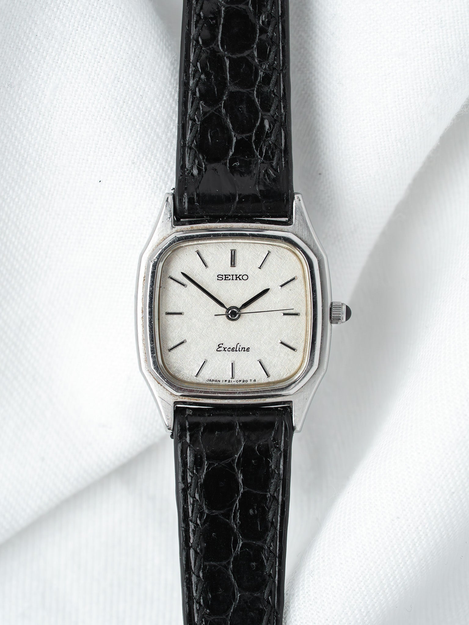 Seiko Exceline vintage watch with silver dial and black alligator strap on white fabric