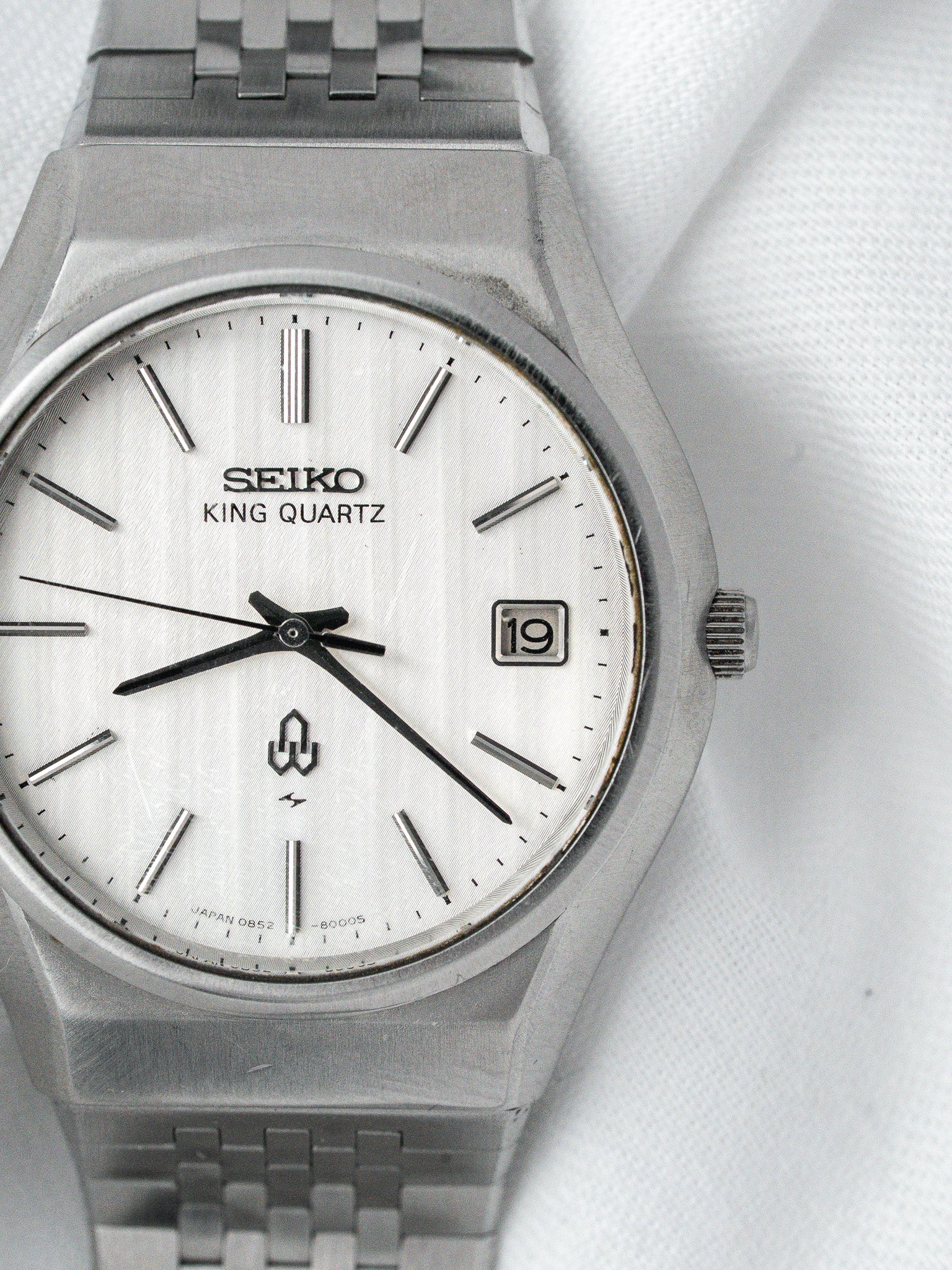 Seiko King Quartz vintage watch with silver dial and steel bracelet on white fabric
