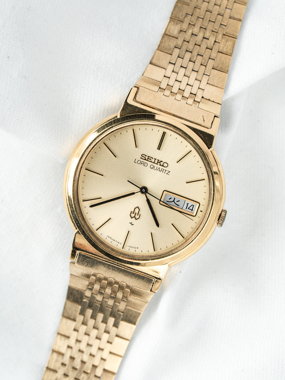 Montre Seiko Lord Quartz vintage en or, cadran champagne, sur fond blanc