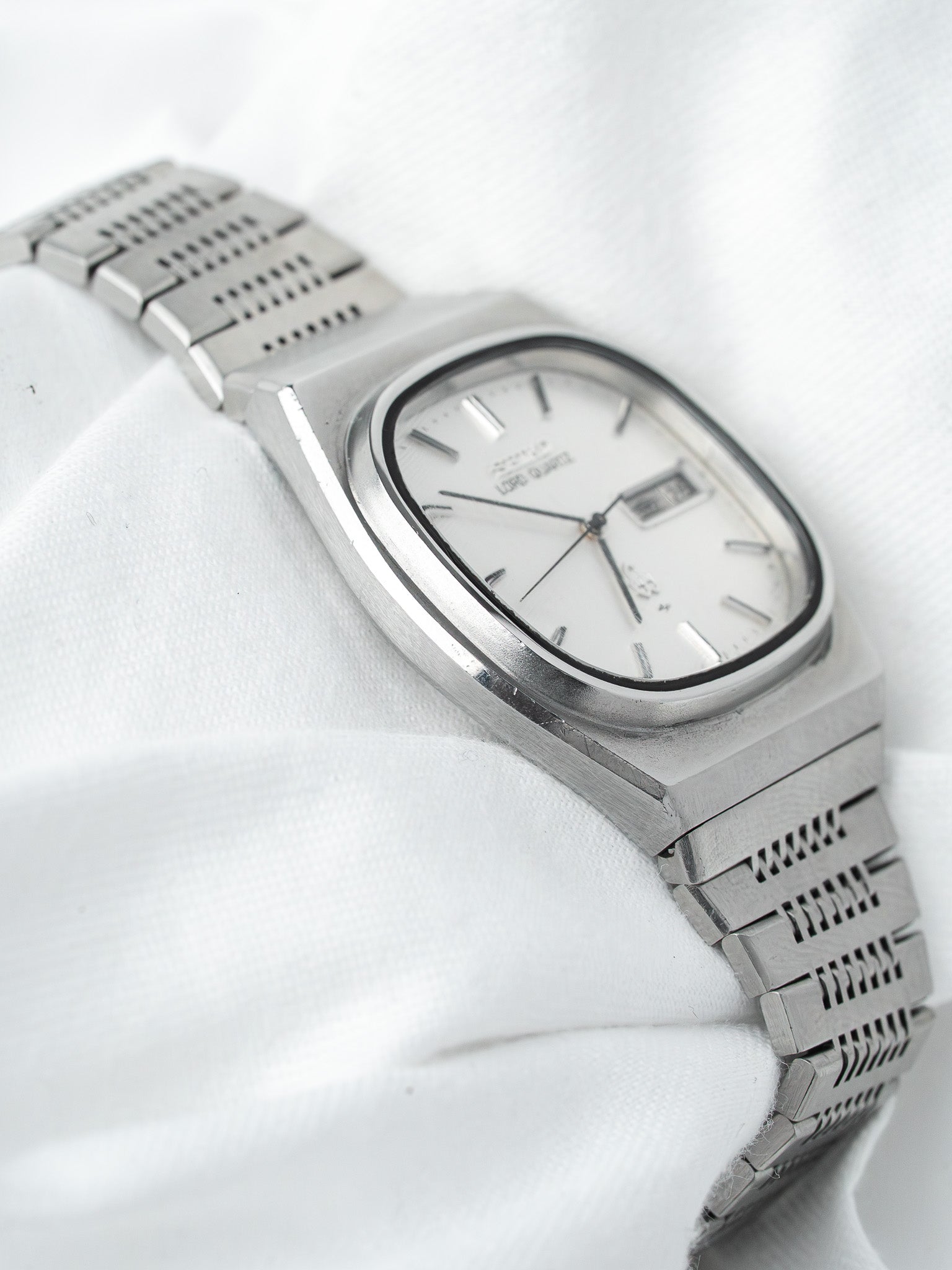 Omega Constellation vintage watch with silver dial and steel bracelet on white fabric