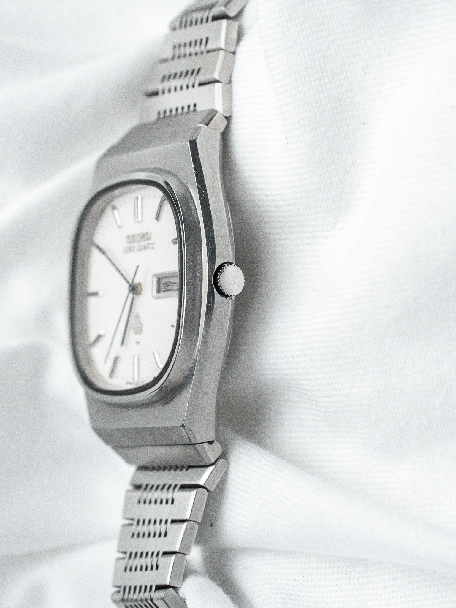 Seiko Lord Quartz vintage watch with silver dial and steel bracelet on white fabric