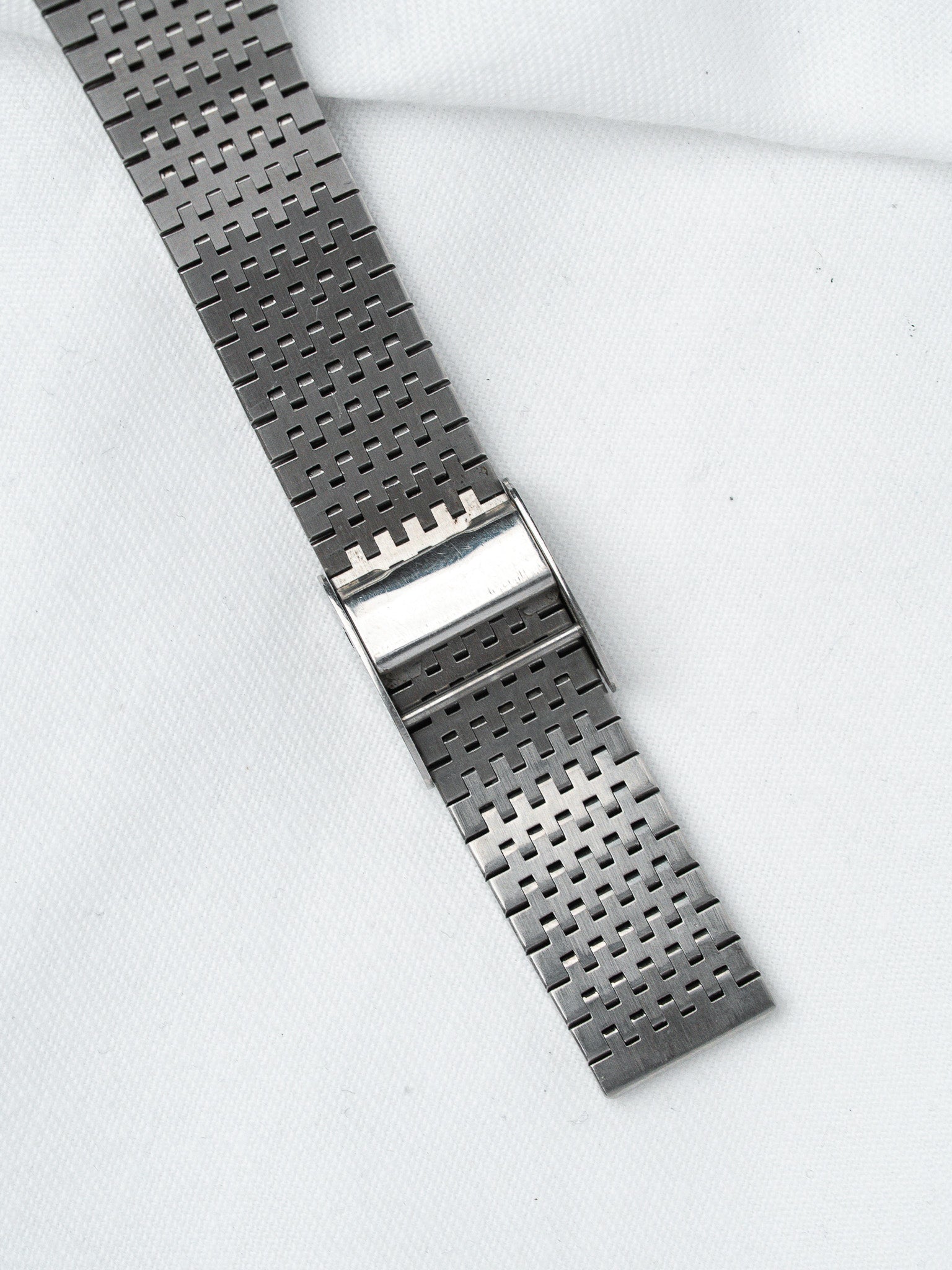Vintage Omega watch bracelet in stainless steel with mesh design on white background