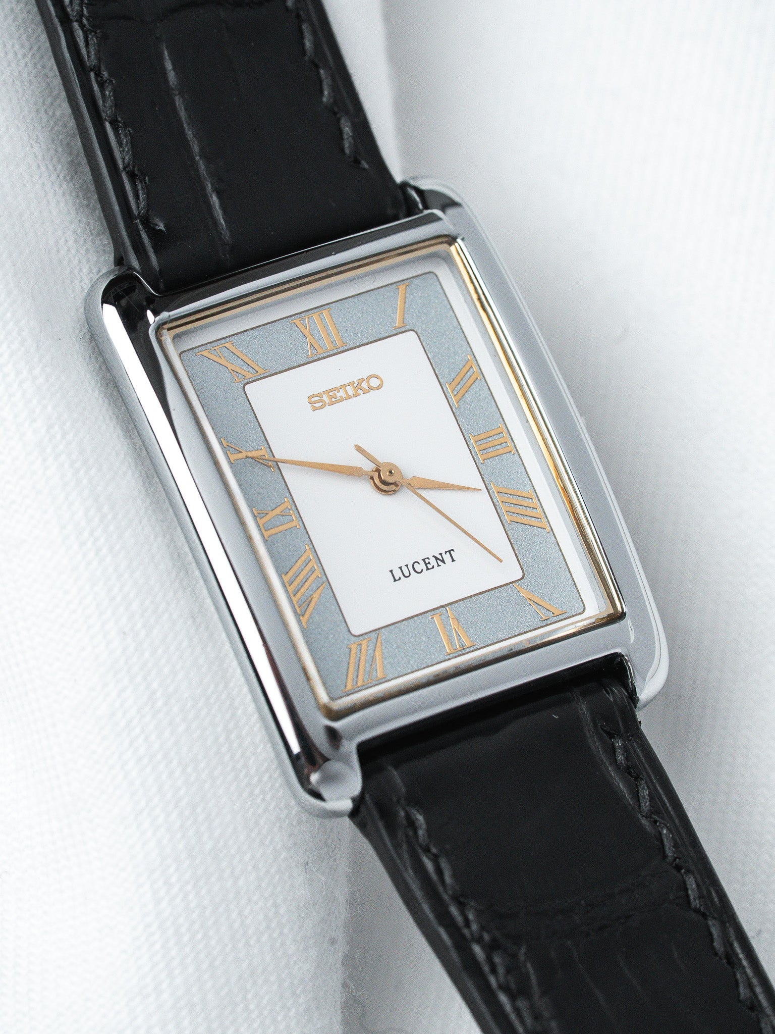Seiko Lucent vintage watch with rectangular case, silver dial, Roman numerals, black leather strap